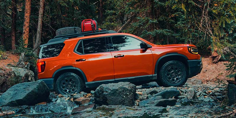 Orange 2026 Honda Passport driving through mountains near Tupelo, MS